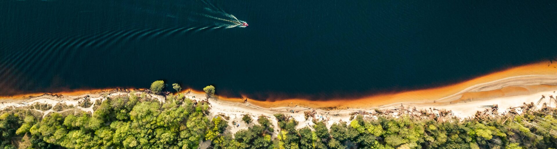 aerial-view-speedboat-sailing-along-river-shore-golden-sand (2)
